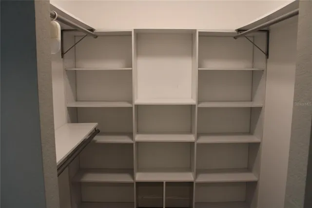 a view of walk in closet with empty racks