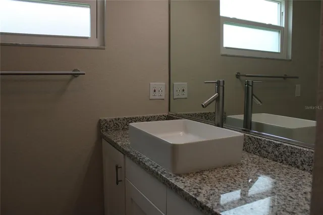 a bathroom with a sink a toilet and a mirror