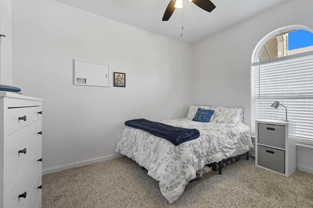 a bedroom with a bed and a ceiling fan