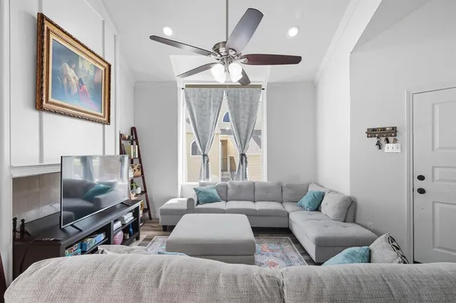 a living room with furniture a flat screen tv and a window