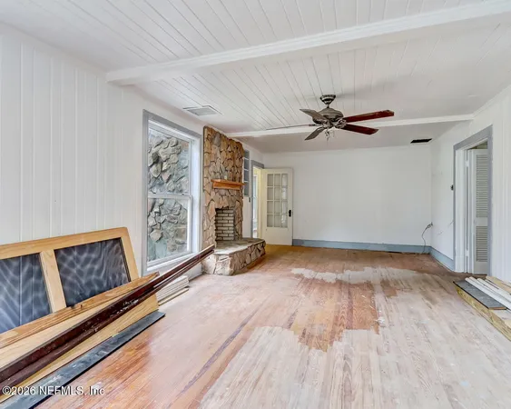 a view of an empty room with a fireplace and a window