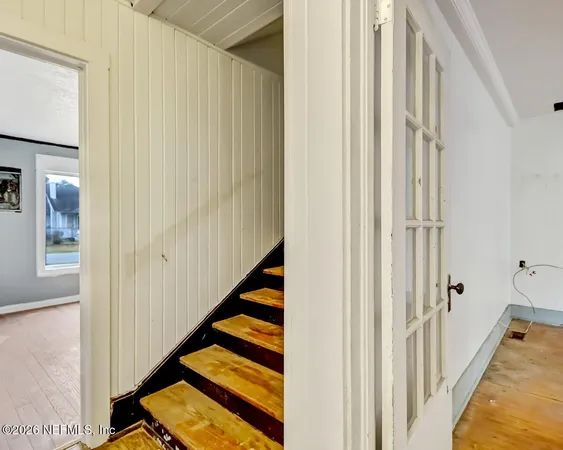 a view of a hallway with wooden floor and staircase