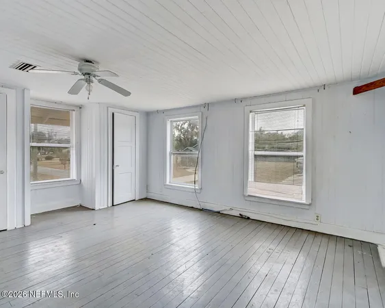 wooden floor in an empty room with a window