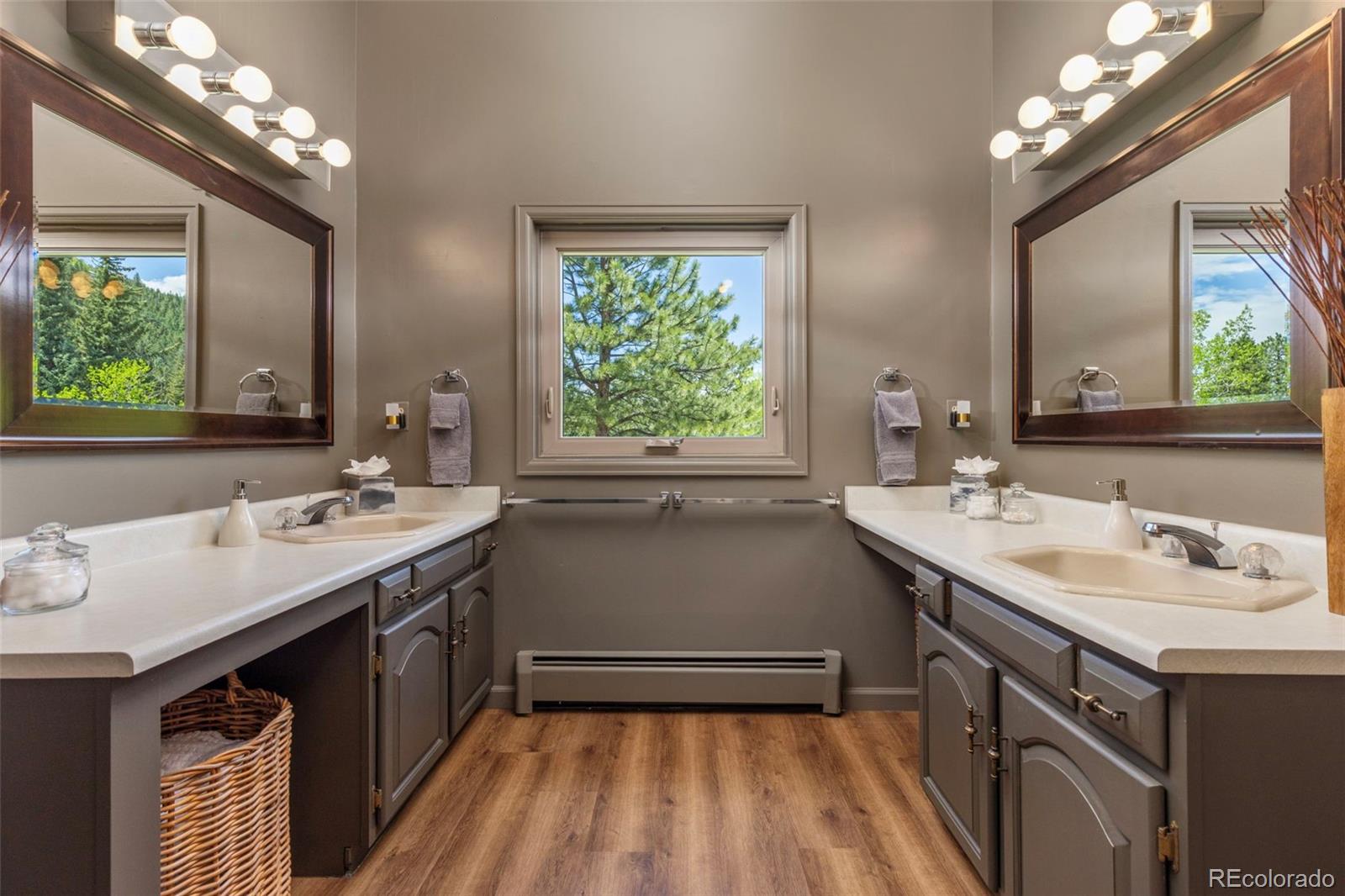 1323 South Snyder Gulch Road Evergreen, CO 80439 - Photo 37 of 47 a bathroom with a sink a large mirror and a window
