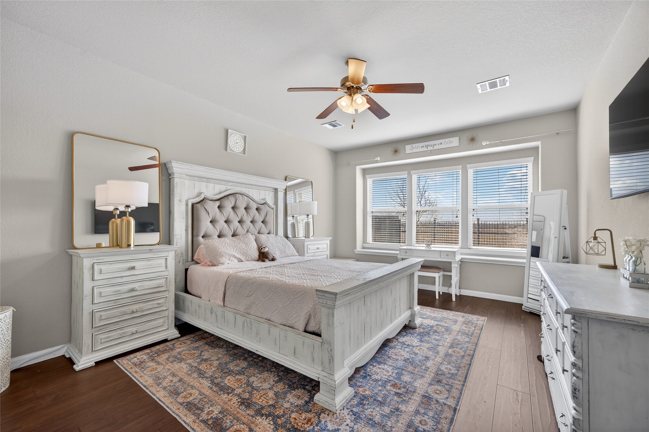 361 Lake Line Drive Alvin, TX 77511 - Photo 10 of 36 The main-floor primary suite is a sanctuary of comfort, featuring warm wood-look flooring, a cooling ceiling fan, and plenty of space for oversized furniture.