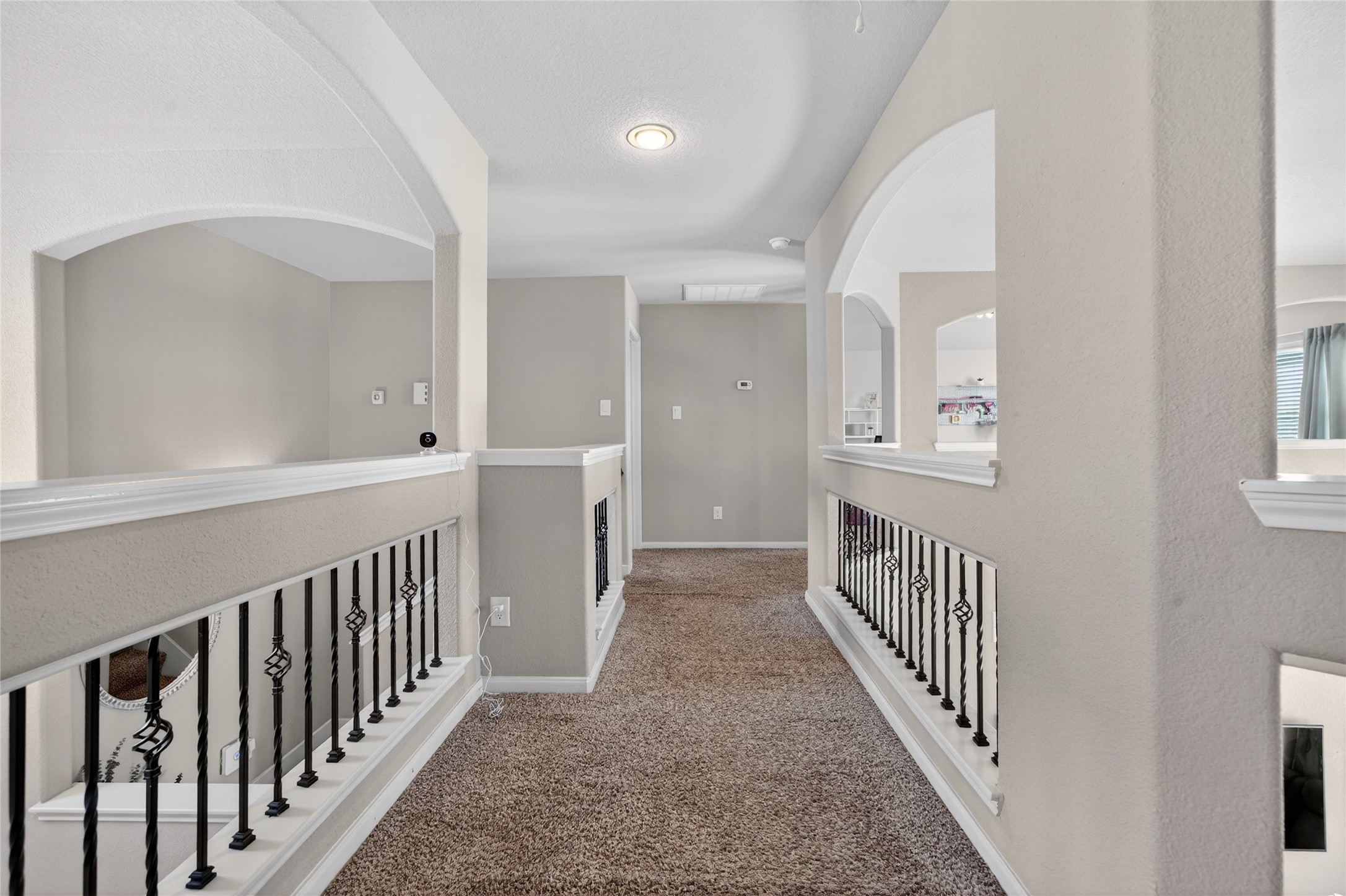 361 Lake Line Drive Alvin, TX 77511 - Photo 15 of 36 Wide, light-filled hallways connect the upper-level bedrooms, ensuring a sense of privacy while maintaining a cohesive flow throughout the home’s layout."