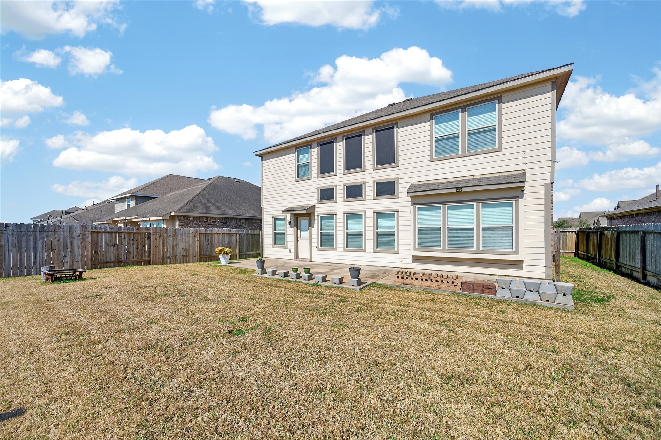 361 Lake Line Drive Alvin, TX 77511 - Photo 23 of 36 The impressive rear elevation showcases a massive wall of windows and a private, fully fenced backyard, offering plenty of space for outdoor entertaining or future projects."