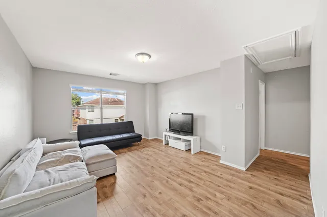 a living room with furniture a flat screen tv and a window