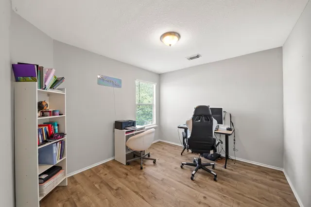 a view of a workspace with furniture and a window