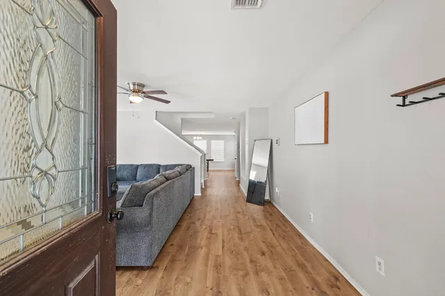 a view of a hallway with wooden floor and staircase