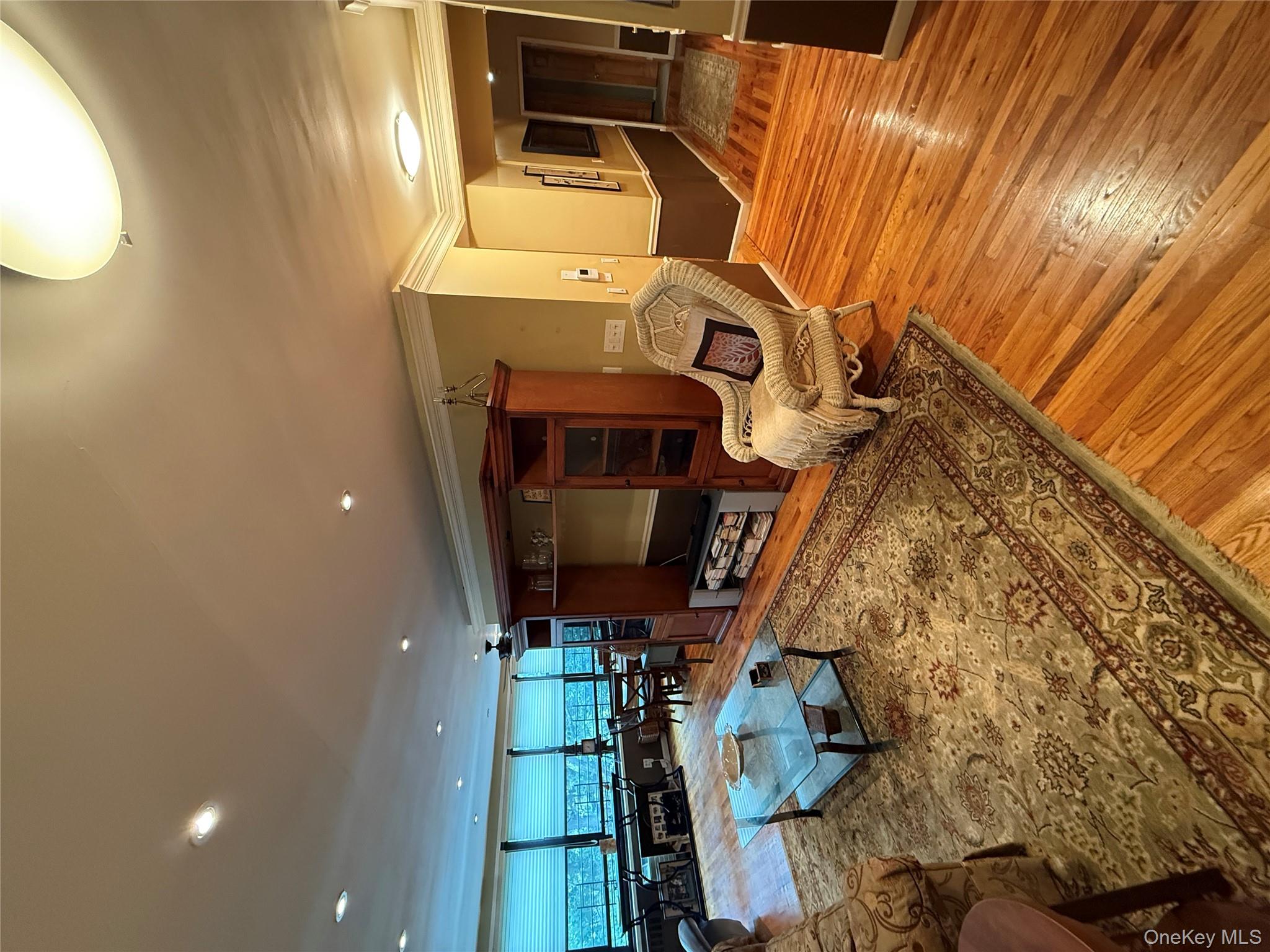 75-34 Bell Boulevard, Unit 6H Queens, NY 11364 - Photo 2 of 8 a living room with furniture and a flat screen tv