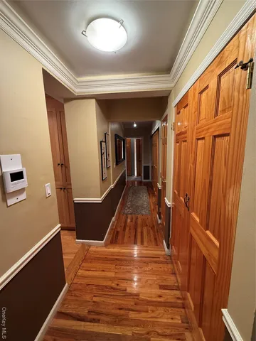 a view of a hallway with wooden floor and staircase