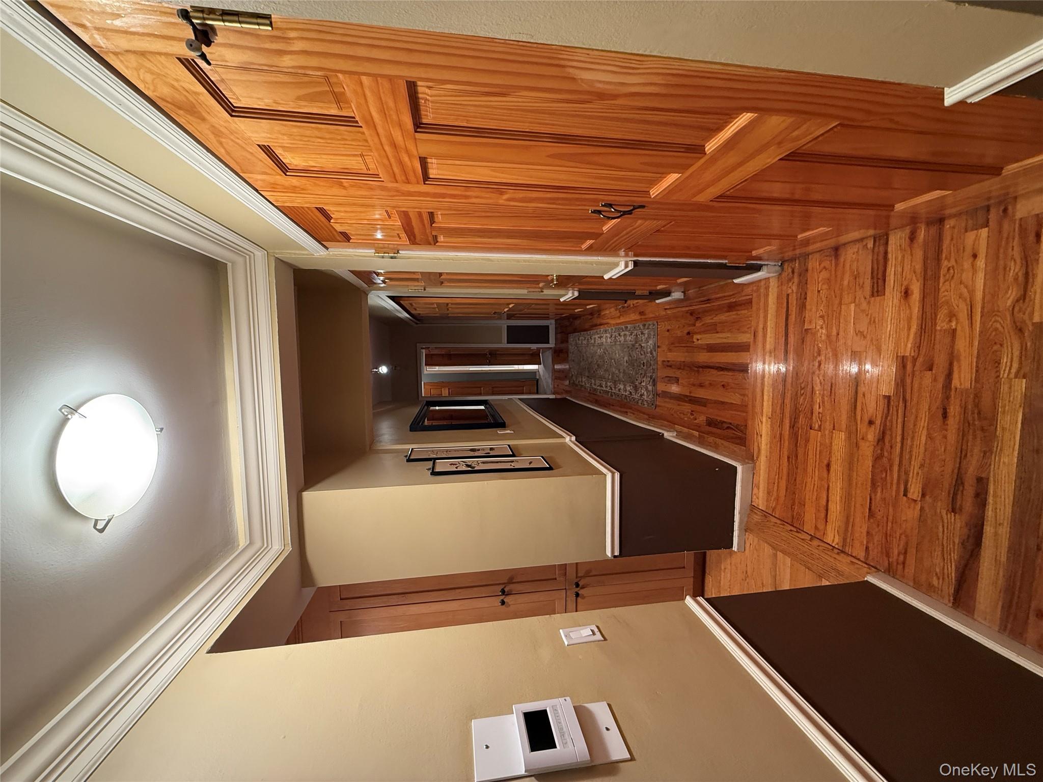 75-34 Bell Boulevard, Unit 6H Queens, NY 11364 - Photo 4 of 8 a view of a hallway with wooden floor and staircase