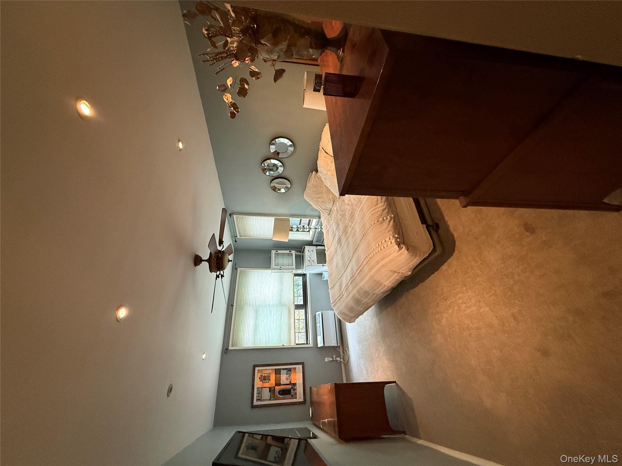 75-34 Bell Boulevard, Unit 6H Queens, NY 11364 - Photo 5 of 8 a bedroom with a bed and window