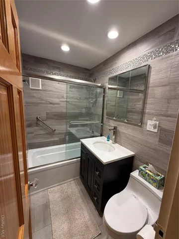 a bathroom with a double vanity sink toilet and mirror