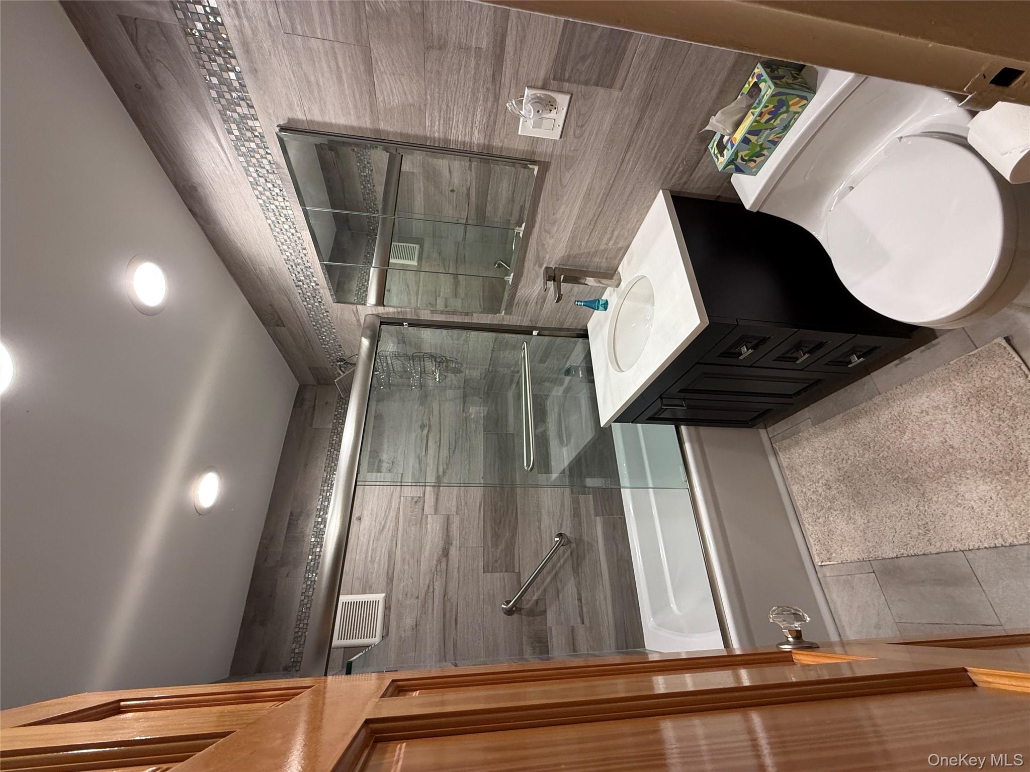 75-34 Bell Boulevard, Unit 6H Queens, NY 11364 - Photo 7 of 8 a bathroom with a double vanity sink toilet and mirror