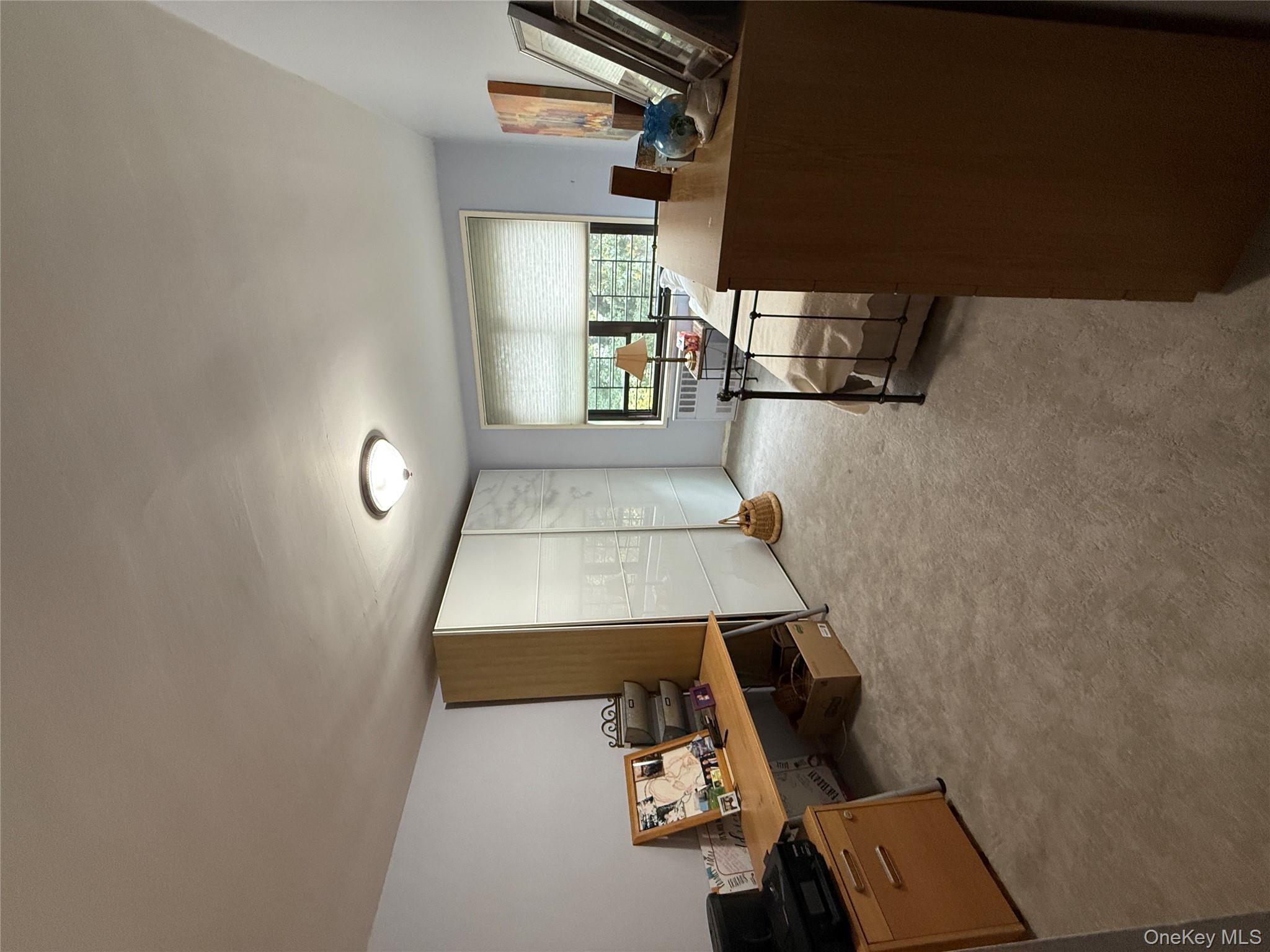 75-34 Bell Boulevard, Unit 6H Queens, NY 11364 - Photo 8 of 8 a view of a livingroom with workspace and a window