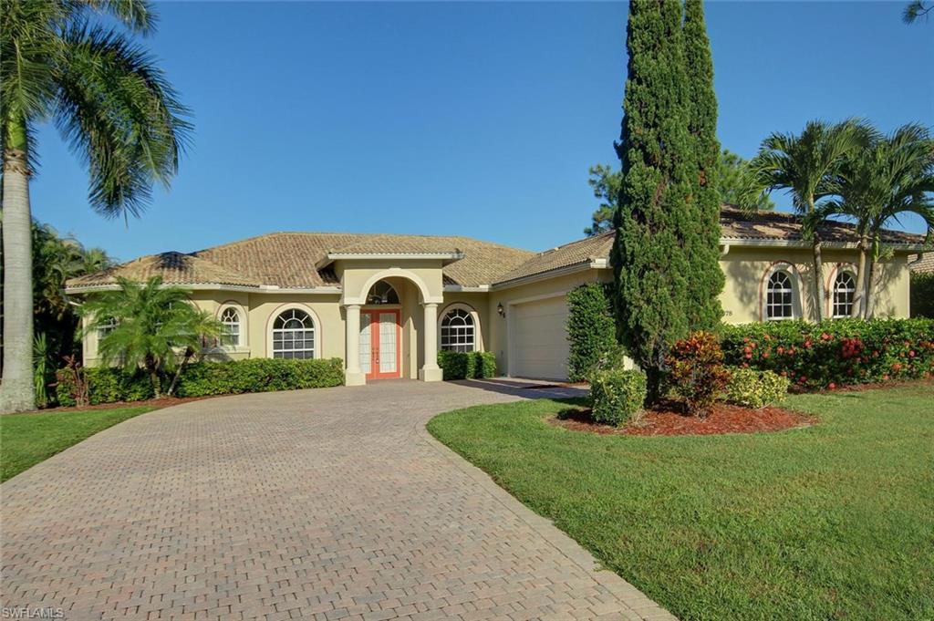 a front view of a house with a garden and trees
