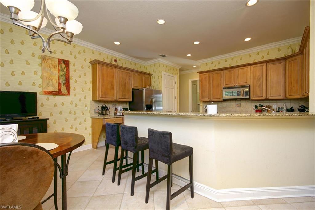 24978 Paradise Road Bonita Springs, FL 34135 - Photo 7 of 25 a kitchen with stainless steel appliances granite countertop a stove a sink a refrigerator and a microwave