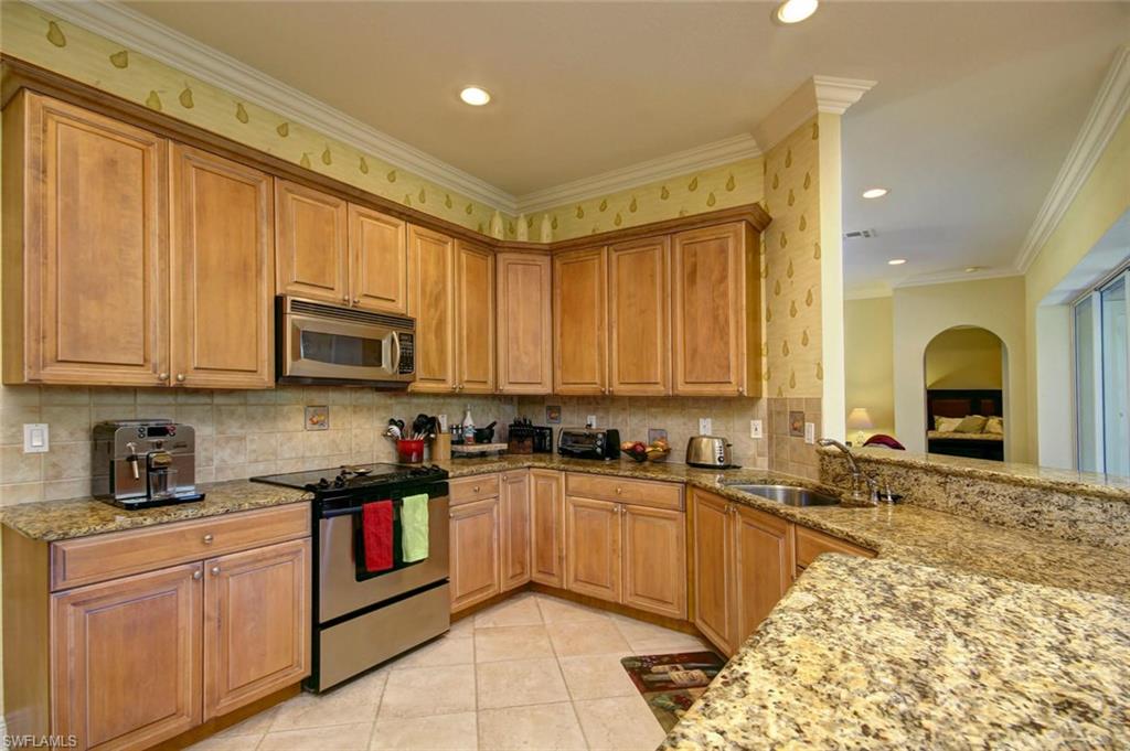 24978 Paradise Road Bonita Springs, FL 34135 - Photo 8 of 25 a kitchen with stainless steel appliances granite countertop a sink stove and cabinets