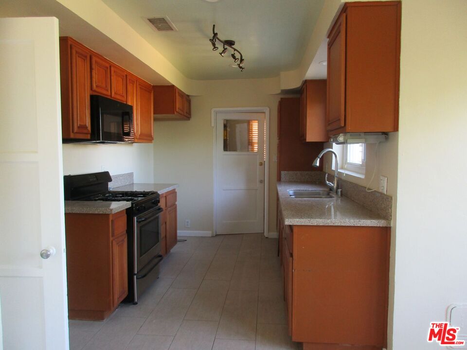 5108 Valley Ridge Avenue View Park, CA 90043 - Photo 15 of 33 a kitchen with stainless steel appliances granite countertop a sink stove and refrigerator