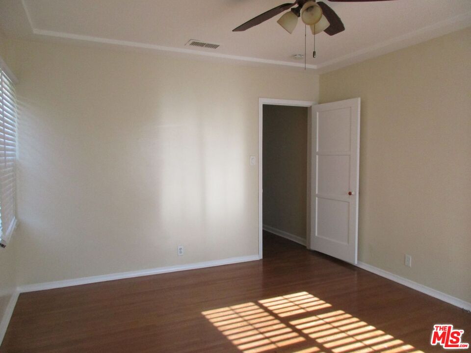 5108 Valley Ridge Avenue View Park, CA 90043 - Photo 20 of 33 a view of wooden floor and chandelier fan in a room