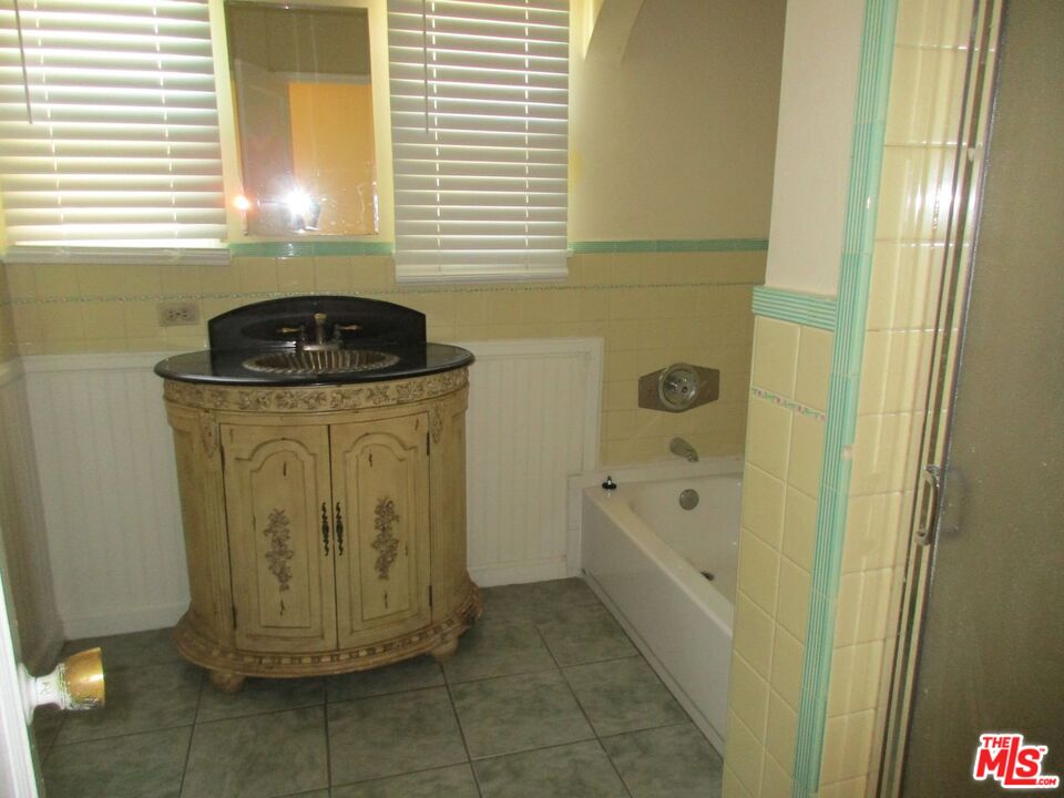 5108 Valley Ridge Avenue View Park, CA 90043 - Photo 22 of 33 a bathroom with a granite countertop sink a toilet and shower