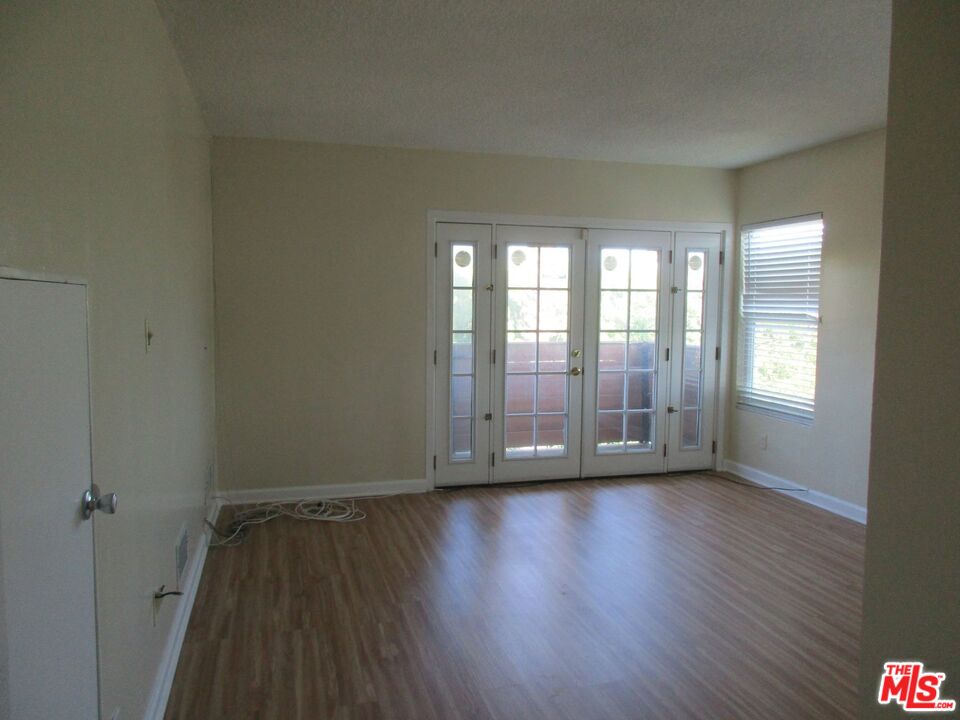5108 Valley Ridge Avenue View Park, CA 90043 - Photo 30 of 33 an empty room with wooden floor and windows