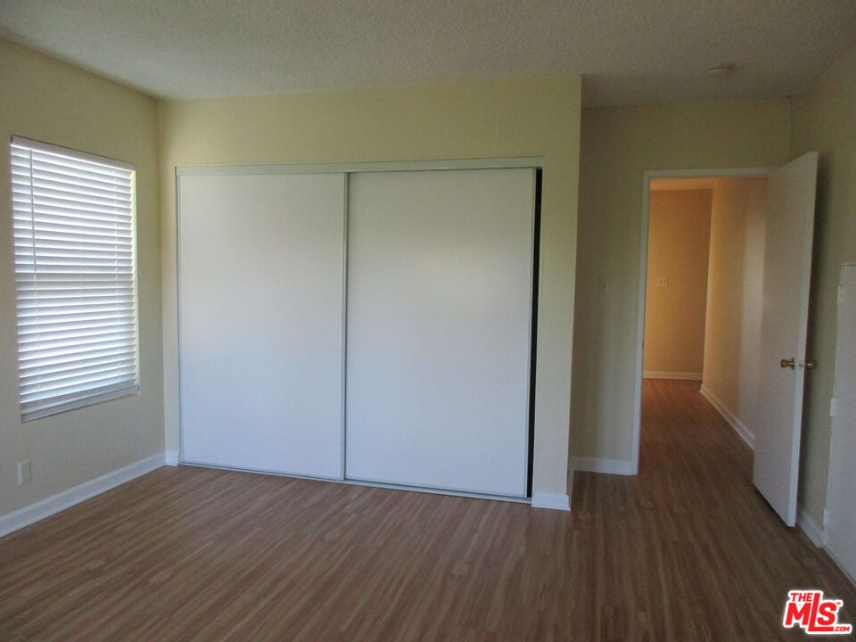 5108 Valley Ridge Avenue View Park, CA 90043 - Photo 31 of 33 an empty room with wooden floor and closet