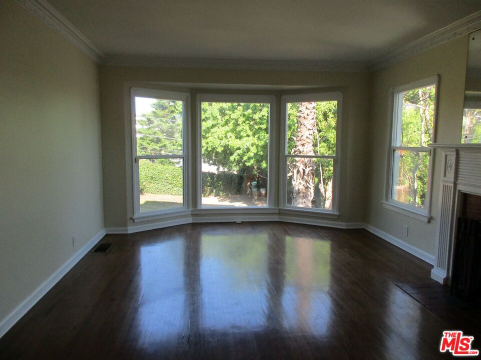 5108 Valley Ridge Avenue View Park, CA 90043 - Photo 7 of 33 an empty room with wooden floor and windows