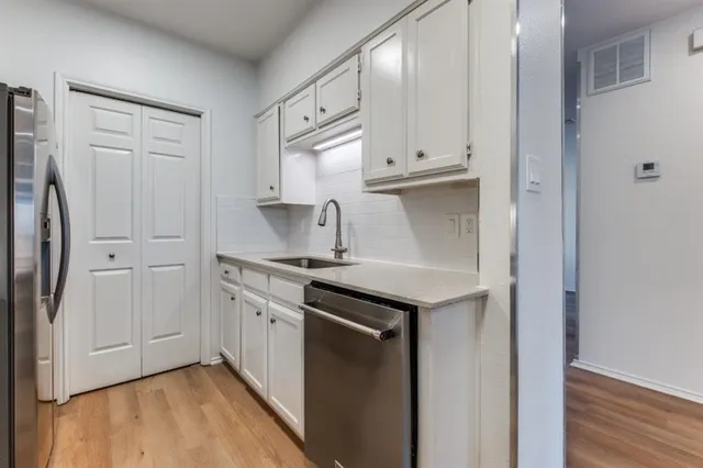 a kitchen with stainless steel appliances granite countertop a sink and a refrigerator