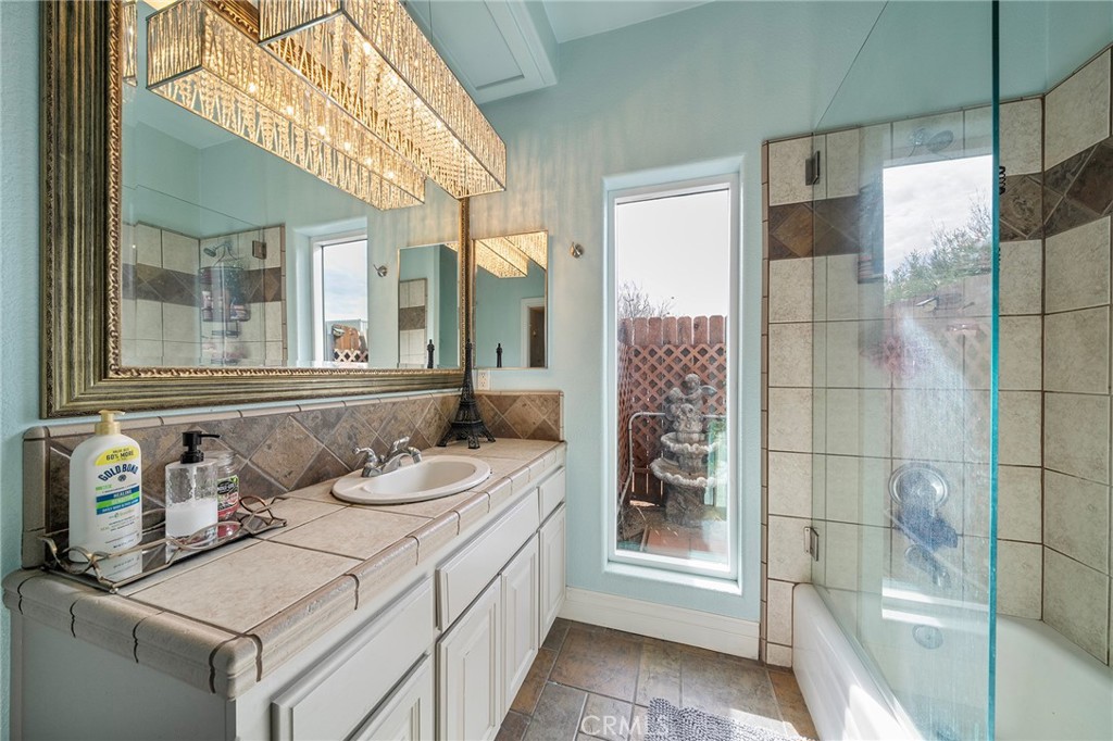 7172 Jargon Road Hesperia, CA 92344 - Photo 35 of 75 a bathroom with a granite countertop sink and a mirror