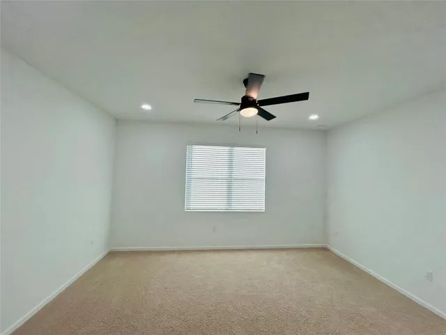 an empty room with a window and a ceiling fan