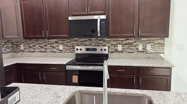 a kitchen with granite countertop a stove and a sink