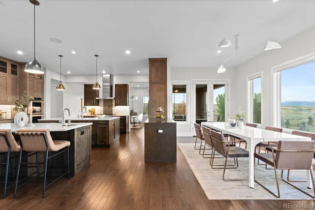 a kitchen with kitchen island a sink stainless steel appliances and wooden floor