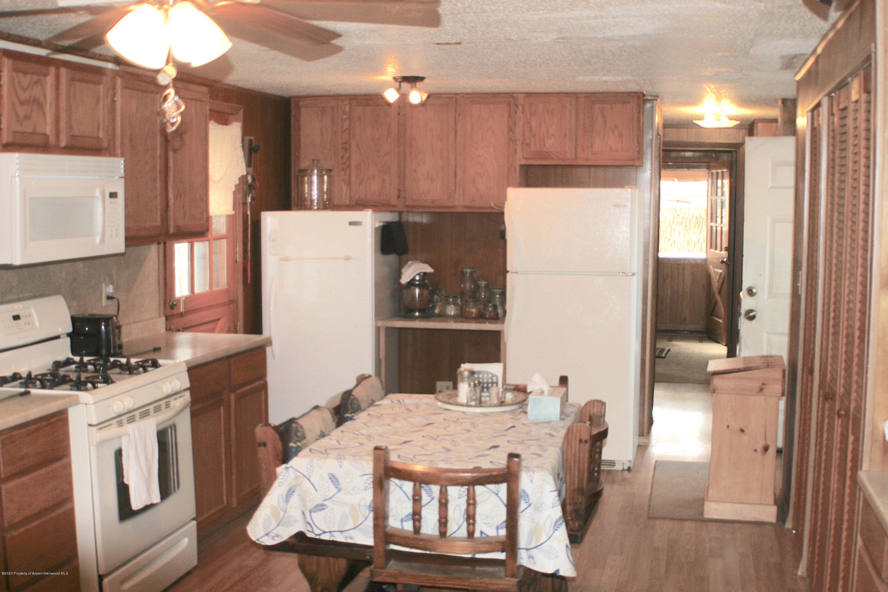 7 St John Circle Parachute, CO 81635 - Photo 6 of 18 a kitchen with stainless steel appliances granite countertop a refrigerator a stove a sink dishwasher and a dining table with wooden floor