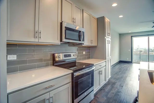 a kitchen with stainless steel appliances a stove microwave and sink