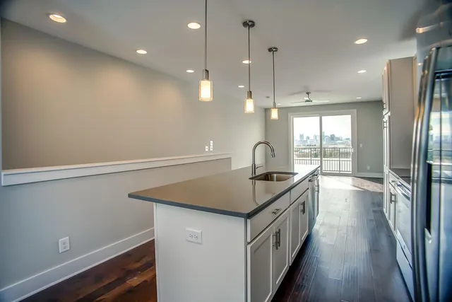 a kitchen that has a lot of cabinets and wooden floor