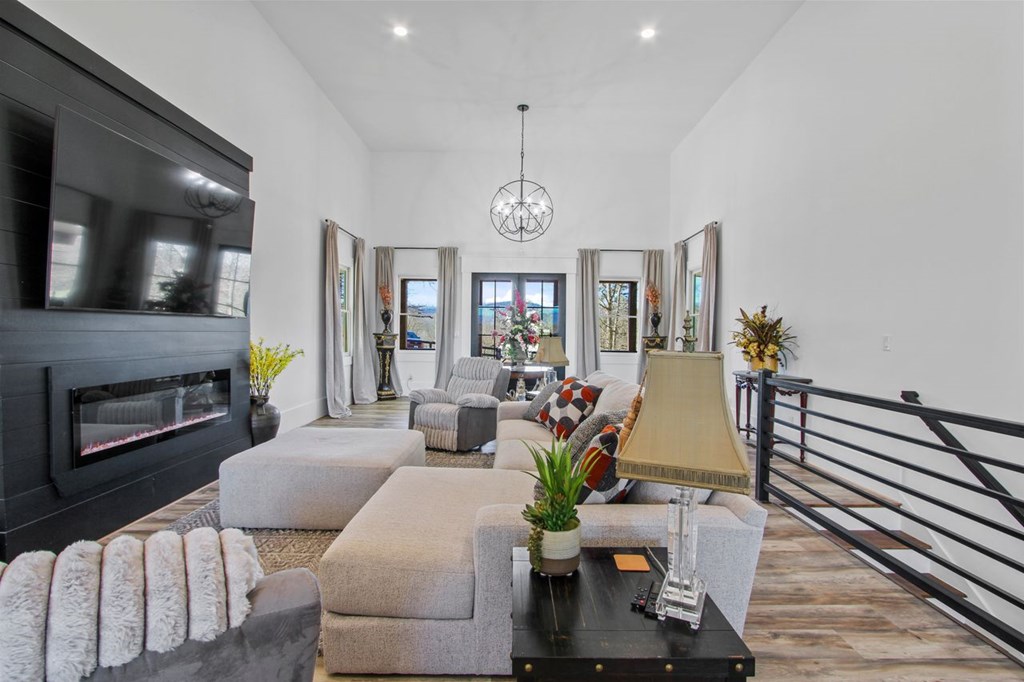 2086 Burnt Mountain Road Ellijay, GA 30536 - Photo 6 of 47 a living room with furniture a chandelier and a flat screen tv