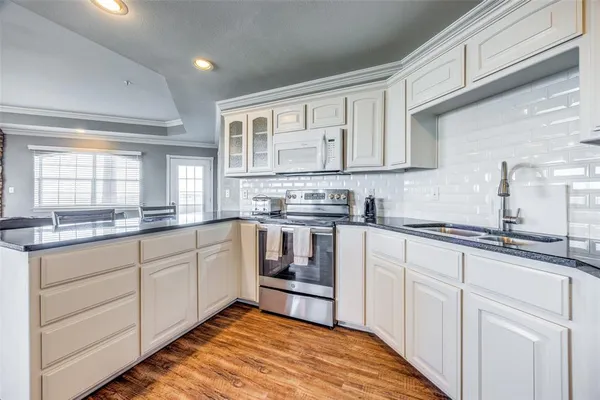 a kitchen with granite countertop white cabinets and white appliances