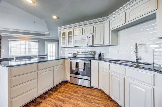 a kitchen with granite countertop white cabinets and white appliances