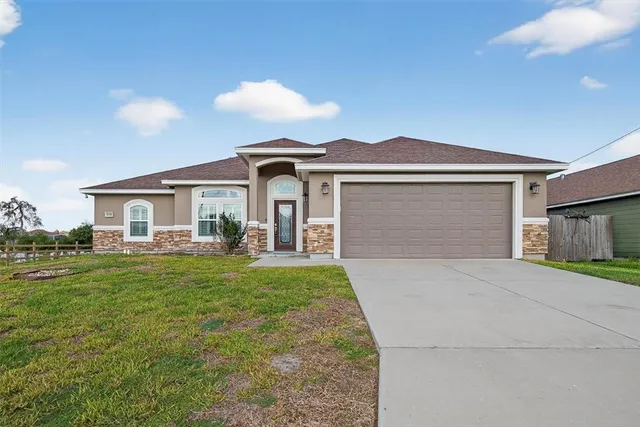 a front view of a house with a garden and yard