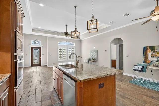 a kitchen with stainless steel appliances granite countertop a sink and a refrigerator