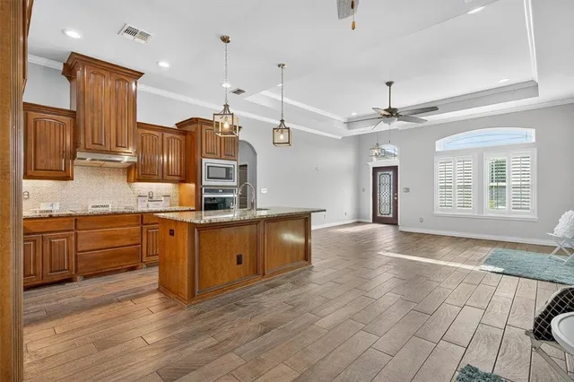 a kitchen with stainless steel appliances granite countertop a stove a sink and a refrigerator
