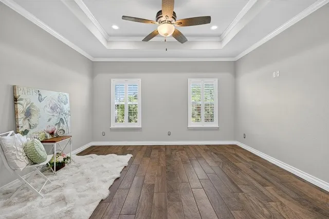 a view of an empty room with a window and wooden floor