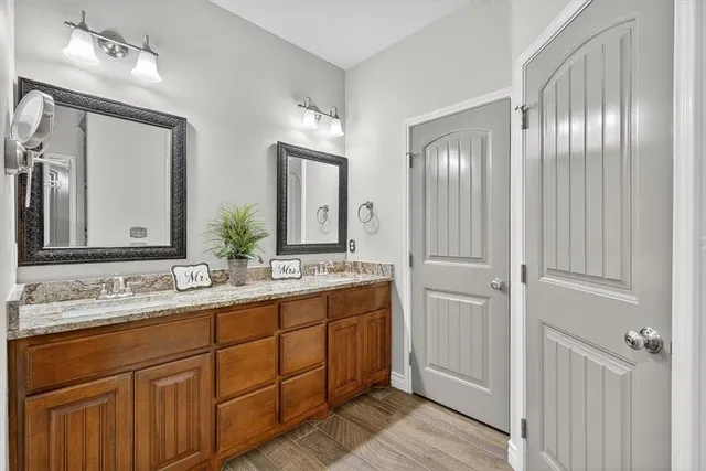 a bathroom with double vanity sinks and a mirror