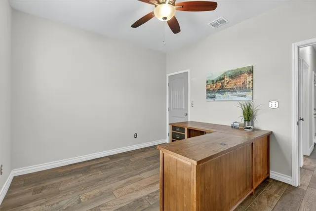 a living room with stainless steel appliances granite countertop furniture and a wooden floor