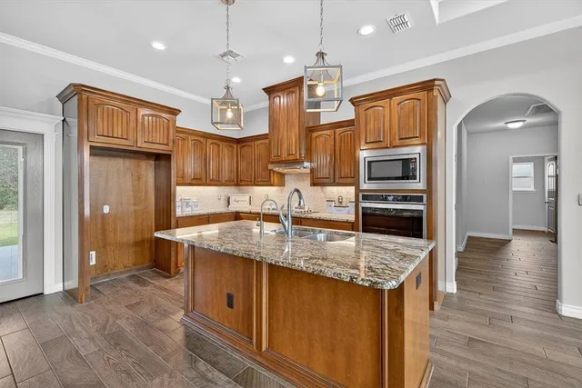 a kitchen with stainless steel appliances granite countertop a sink stove and refrigerator
