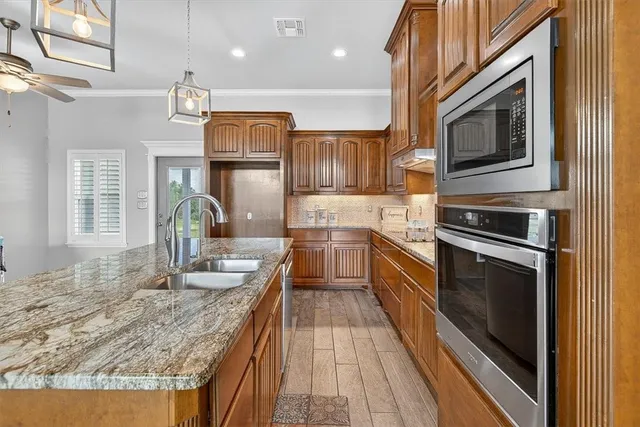 a kitchen with granite countertop a stove top oven and cabinets
