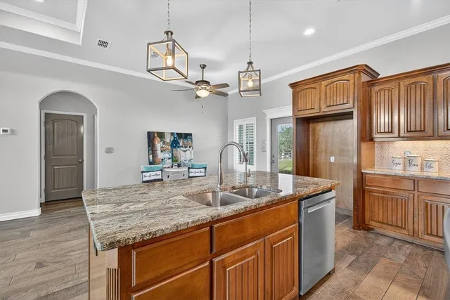 a kitchen with kitchen island granite countertop wooden cabinets and a refrigerator